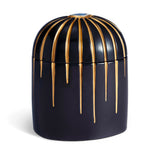 Dark blue cylinder candle posed from side to show gold drip details from eye motif