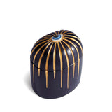 Dark blue cylinder candle with gold details dripping from top eye motif