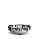 A handmade porcelain decorative bowl with indigo dye drops to flowing down from the rim.