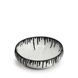 A handmade porcelain decorative bowl with indigo dye drops to flowing down from the rim.