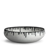 A handmade porcelain decorative bowl with indigo dye drops to flowing down from the rim.