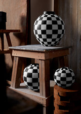 Damier Vase collection with black and white checkerboard glaze pattern on orb-shaped porcelain vases.
