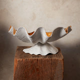 Neptune Bowl - X-Large. White porcelain shell-shaped bowl with gold interior floating on a base.