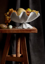 Neptune Bowl - Large. White porcelain shell-shaped bowl floating on a base.