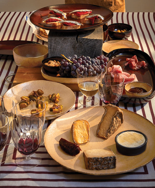 Aperitivo Dinnerparty with Leather and WIne Colored Plates on Striped Linens