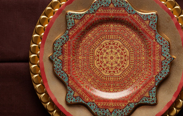 Aegean gold charger plate with wave motif border, Tabriz dessert plate with vibrant red, orange and turquoise tapestry motif.