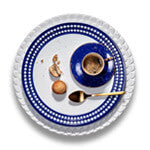 Aegean white charger plate with wave motif border, Perlee white and blue porcelain dinner plate, Lapis blue porcelain espresso cup and saucer.