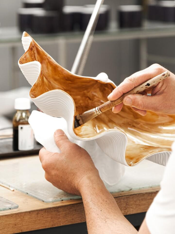 Person working on a taxidermy project with a deer head and skin on a table.