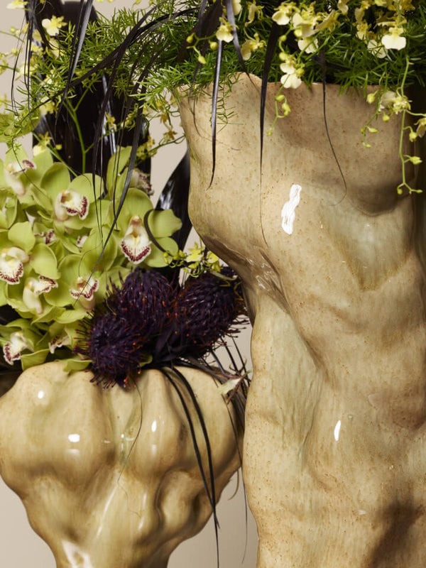 Decorative arrangement with flowers and greenery on a classical sculpture