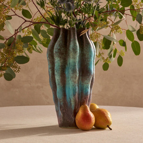 Decorative vase with greenery and fruits on a neutral background