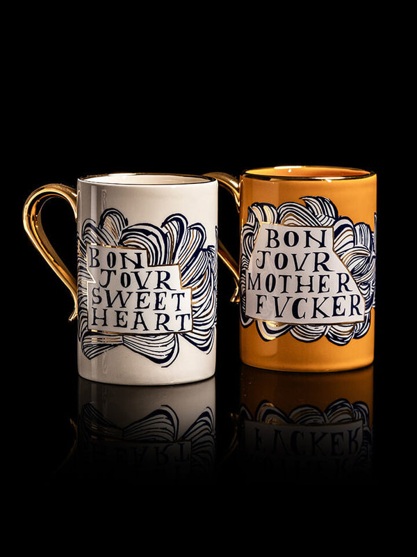 Two mugs with decorative text on a black background