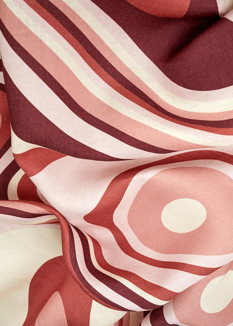 Linen rectangular tablecloth with an organic, undulating pattern in red, pink and ivory hues.