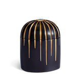 Dark blue cylinder candle posed from side to show gold drip details from eye motif
