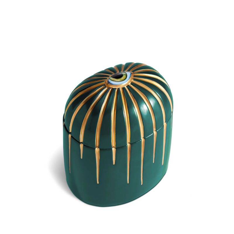 green cylinder candle with gold details dripping from top eye motif
