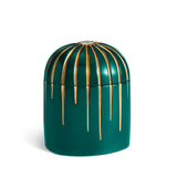 green cylinder candle posed from side to show gold drip details from eye motif
