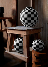 Damier Vase collection  with black and white checkerboard glaze pattern on orb-shaped porcelain vases.