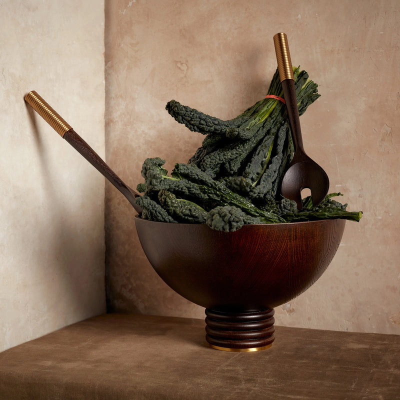 Alhambra hand-carved, fine smoked ash bowl floating on stacked wood pedestal with a brass base.  Alhambra  serving utensil set.